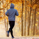 runner in a hoodie amongst the fall leaves
